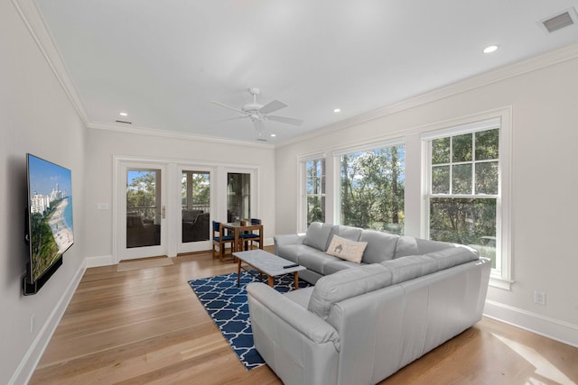 living area featuring visible vents, light wood-style floors, and a healthy amount of sunlight