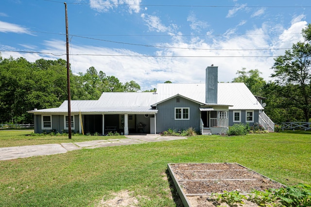 225 Baxter Ln, Walterboro, SC 29488 - rear view of house featuring a chimney, metal roof, a yard, and a vegetable garden
