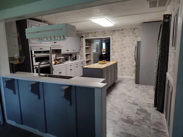 225 Baxter Ln, Walterboro, SC 29488 - kitchen featuring a sink, stainless steel appliances, a breakfast bar, a center island, and white cabinets
