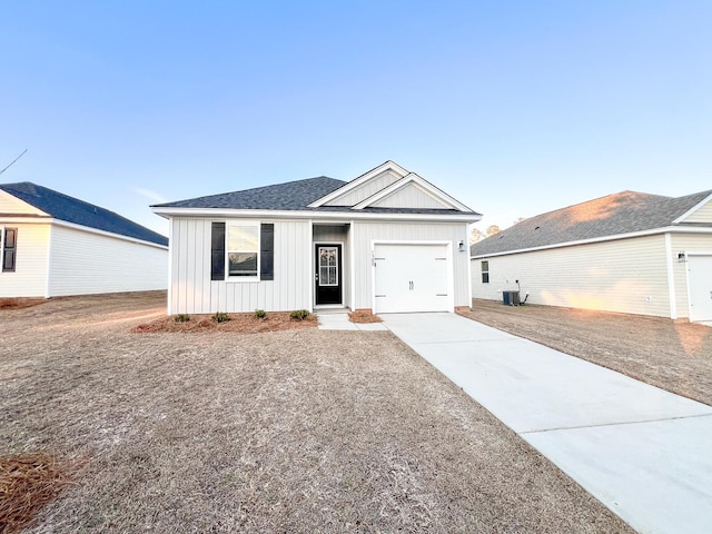 view of front of home featuring a garage and cooling unit