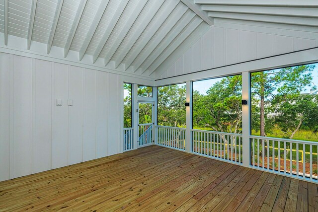 unfurnished sunroom featuring vaulted ceiling with beams