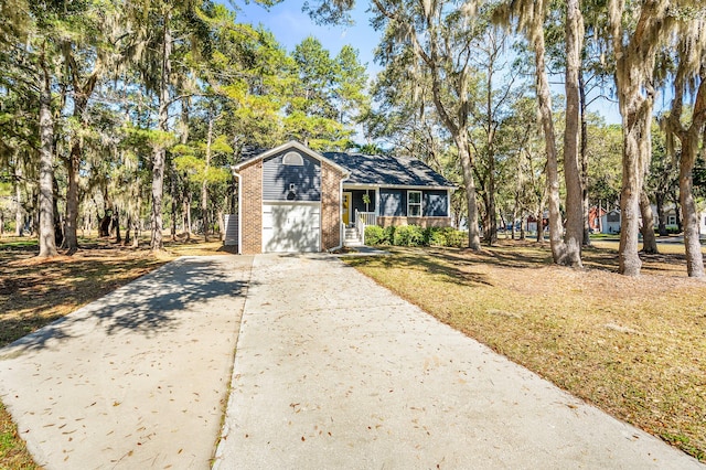 view of front of home with brick siding, driveway, a front yard, and a garage