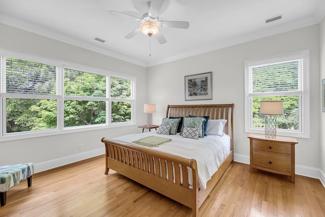bedroom with baseboards, light wood finished floors, ornamental molding, and ceiling fan