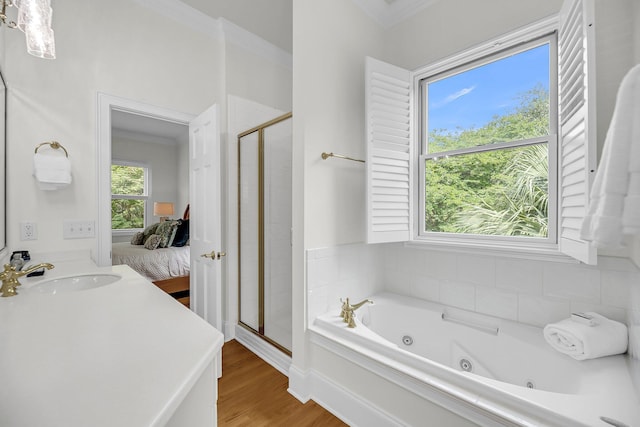 full bathroom with ensuite bath, a shower stall, a whirlpool tub, wood finished floors, and ornamental molding