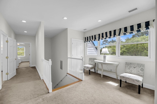hallway with light carpet, baseboards, recessed lighting, and an upstairs landing