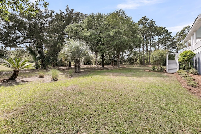 view of green lawn featuring stairs
