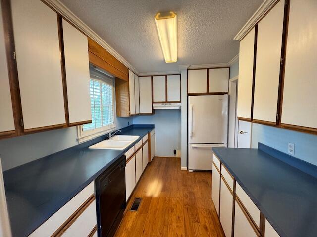 1129 Levi St, Manning, SC 29102 - kitchen featuring freestanding refrigerator, dishwasher, dark countertops, a textured ceiling, and wood finished floors