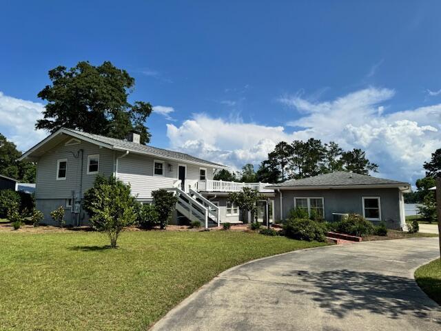 1129 Levi St, Manning, SC 29102 - ranch-style house featuring a front yard, stairway, driveway, and a chimney