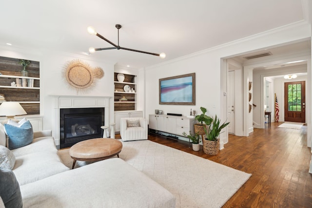 1407 Wando View St, Daniel Island, SC 29492 - living area with ornamental molding, built in features, wood finished floors, a chandelier, and a glass covered fireplace