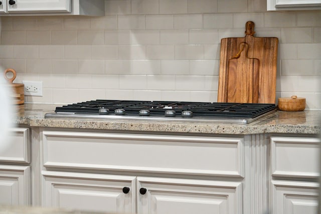 1407 Wando View St, Daniel Island, SC 29492 - kitchen view of stainless steel gas cooktop, tasteful backsplash, and white cabinets