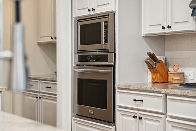 1407 Wando View St, Daniel Island, SC 29492 - kitchen featuring appliances with stainless steel finishes, decorative backsplash, white cabinets, and light stone counters