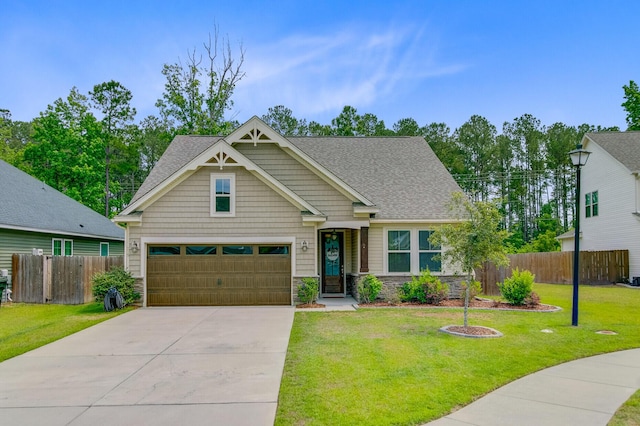 craftsman inspired home with stone siding, fence, concrete driveway, a shingled roof, and a front yard