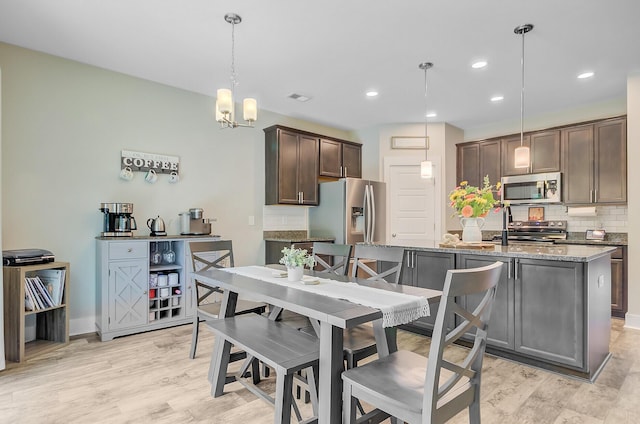 dining space with baseboards, recessed lighting, and light wood-type flooring