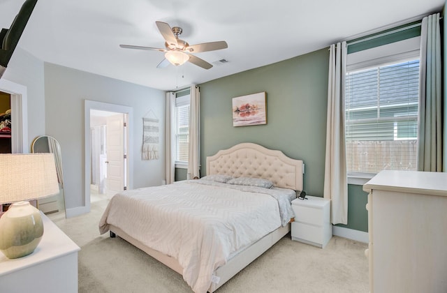 bedroom with light carpet, a ceiling fan, and multiple windows