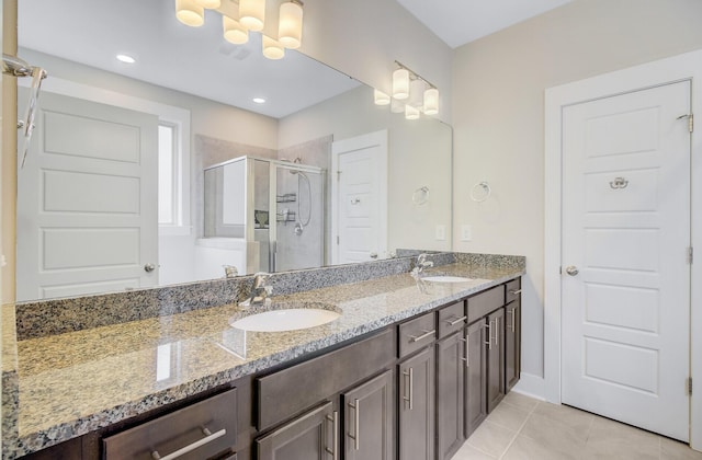 bathroom with double vanity, a sink, tile patterned floors, a shower stall, and a chandelier