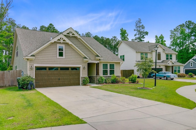 craftsman inspired home featuring fence, stone siding, concrete driveway, a garage, and a front lawn