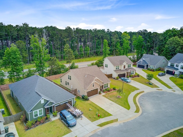 drone / aerial view featuring a forest view and a residential view