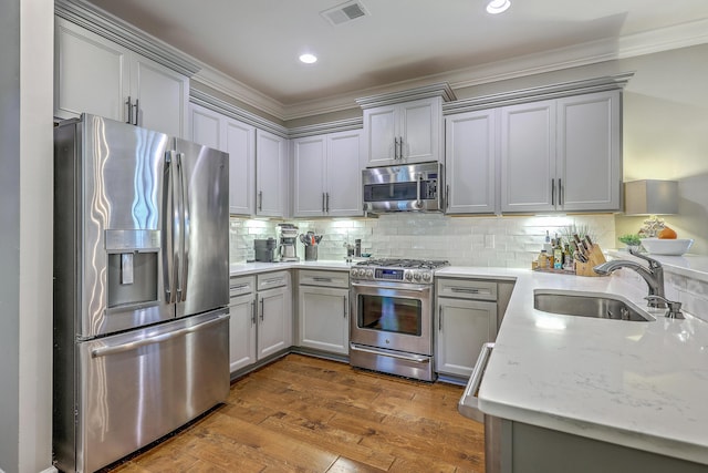 3152 Riverine, Charleston, SC 29414 - kitchen with appliances with stainless steel finishes, a sink, gray cabinetry, dark wood-type flooring, and ornamental molding