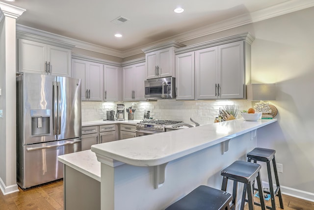 3152 Riverine, Charleston, SC 29414 - kitchen featuring stainless steel appliances, gray cabinetry, a peninsula, a kitchen breakfast bar, and ornamental molding