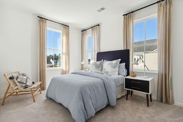 bedroom featuring light carpet and visible vents