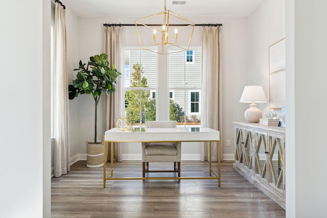 office space with visible vents, wood finished floors, baseboards, and a chandelier