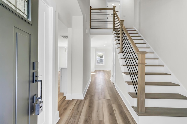 entryway featuring stairway, wood finished floors, visible vents, and baseboards