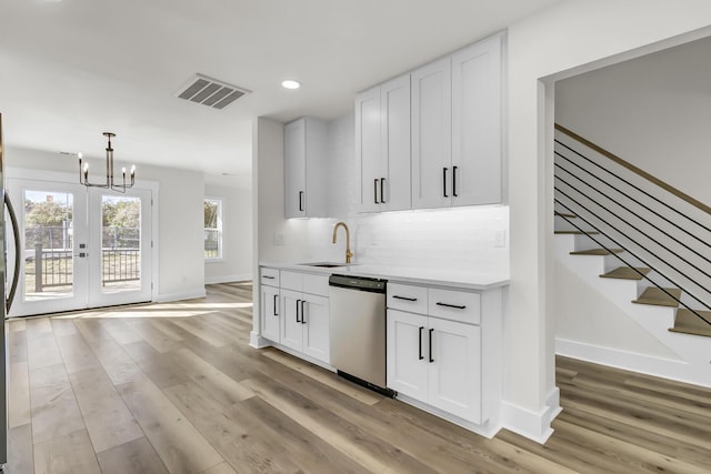 kitchen with light wood-style floors, visible vents, a sink, and stainless steel dishwasher