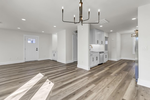 unfurnished dining area featuring light wood finished floors, a sink, and recessed lighting