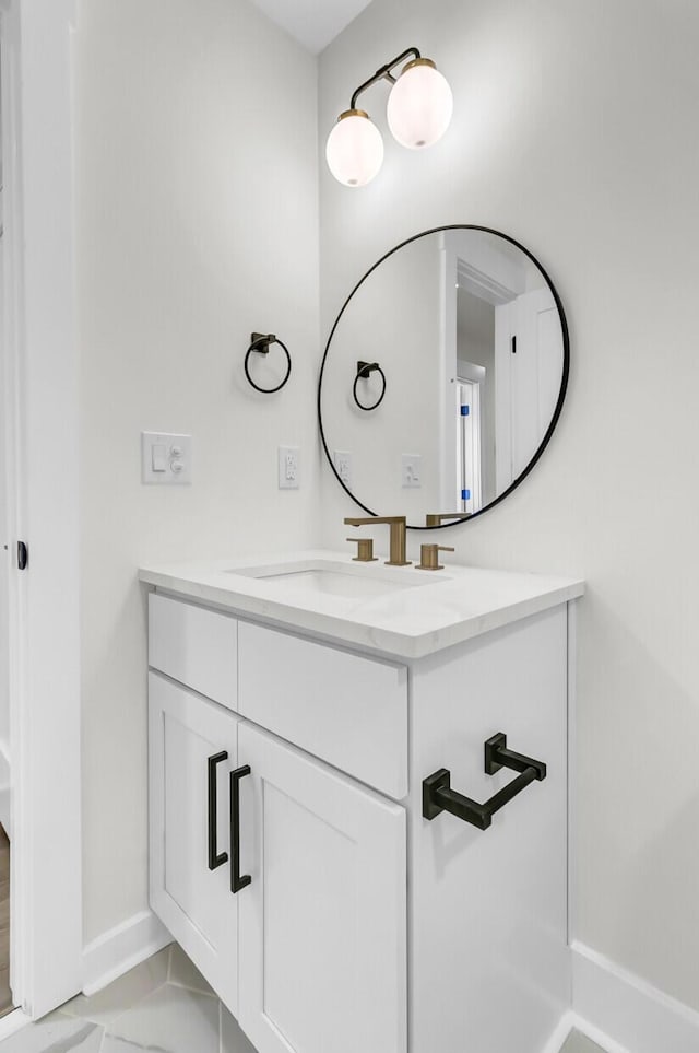 bathroom with marble finish floor, baseboards, and vanity