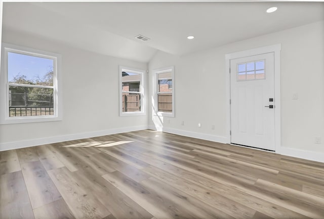 foyer with a healthy amount of sunlight, visible vents, baseboards, and wood finished floors