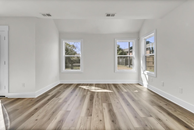 unfurnished room featuring visible vents, baseboards, and wood finished floors