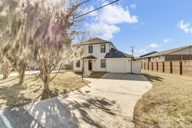 view of front facade with driveway, a garage, fence, and roof with shingles