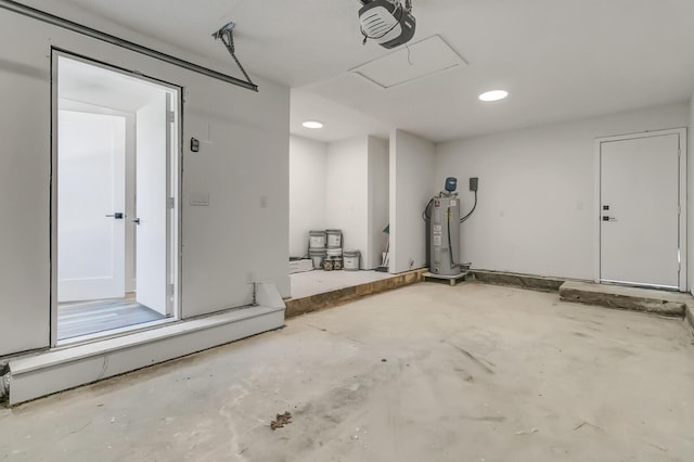 garage featuring recessed lighting, electric water heater, and a garage door opener