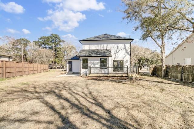 rear view of property featuring fence and a wooden deck