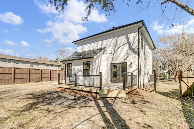 rear view of property featuring fence and a deck