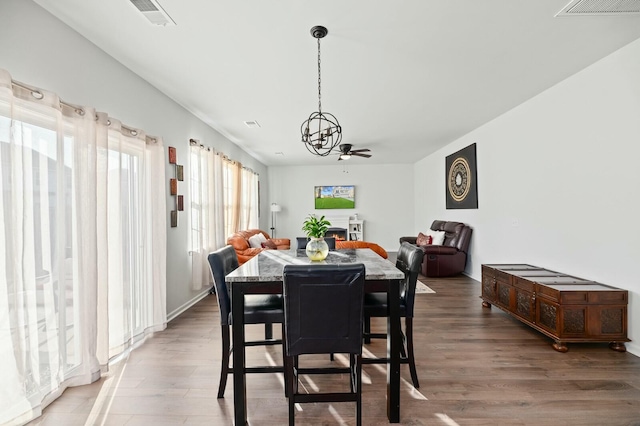 dining room featuring hardwood / wood-style flooring and ceiling fan with notable chandelier