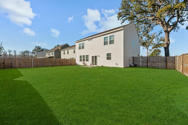 rear view of property featuring central AC and a yard