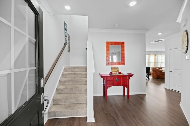 stairs featuring ornamental molding and hardwood / wood-style floors