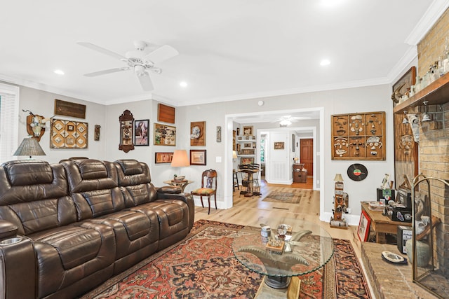 living room featuring ornamental molding, light hardwood / wood-style floors, and ceiling fan