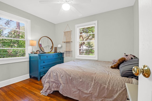 bedroom with multiple windows, hardwood / wood-style flooring, and ceiling fan