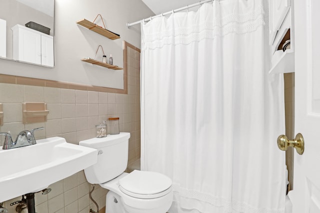 bathroom featuring toilet, a shower with curtain, tile walls, and sink