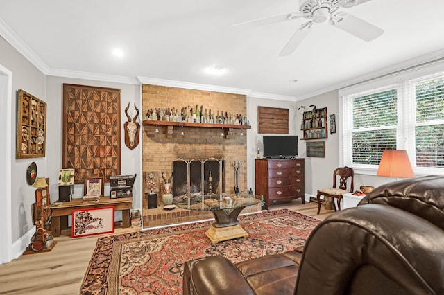 living room featuring a fireplace, ceiling fan, light wood-type flooring, and ornamental molding