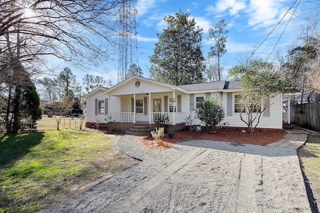 ranch-style house with a front yard and covered porch