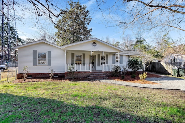 ranch-style house with covered porch and a front lawn