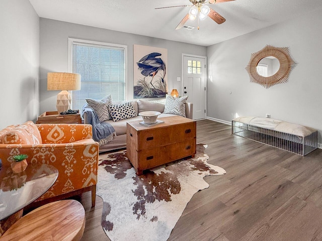 living room with ceiling fan, dark wood-type flooring, and a textured ceiling