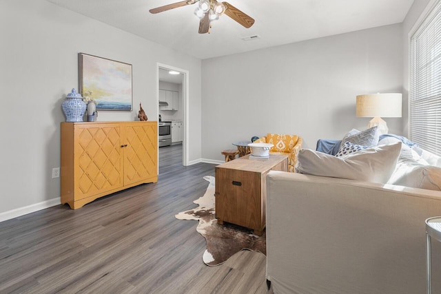 living room featuring dark wood-type flooring and ceiling fan