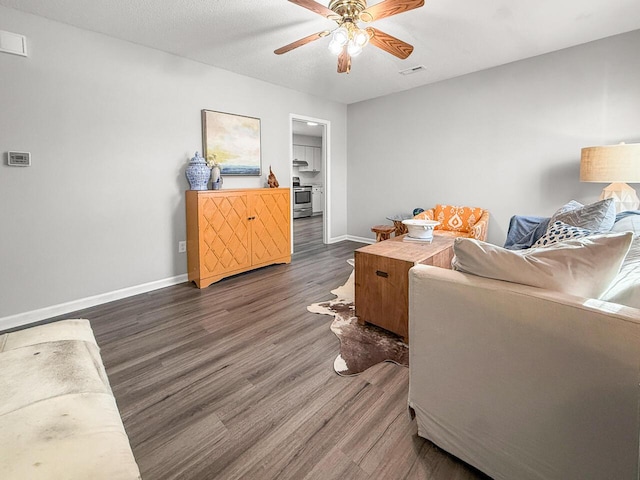 living room featuring ceiling fan, dark hardwood / wood-style flooring, and a textured ceiling