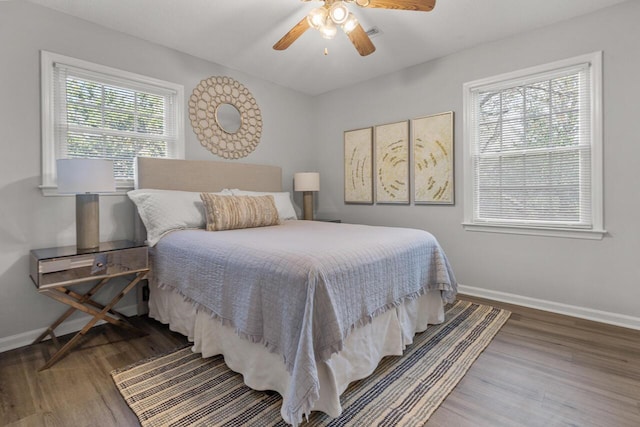 bedroom with ceiling fan, multiple windows, and hardwood / wood-style floors