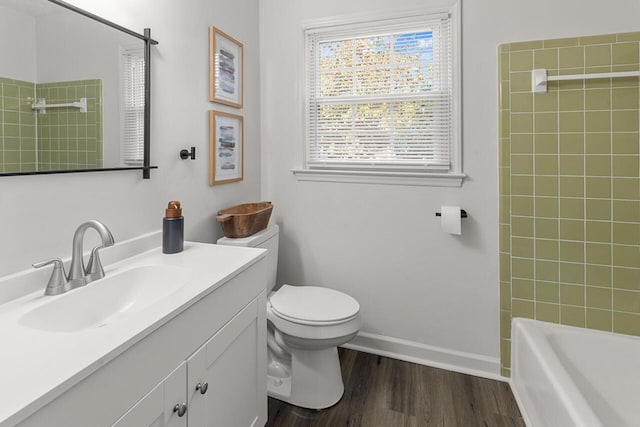 full bathroom with wood-type flooring, toilet, vanity, and tiled shower / bath combo