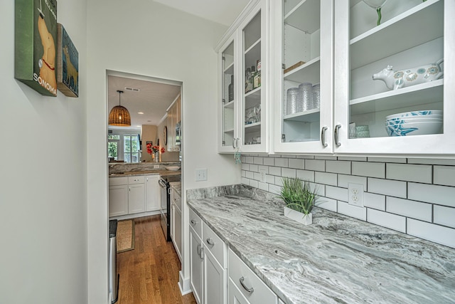 bar featuring white cabinetry, electric range, light stone counters, dark hardwood / wood-style floors, and decorative backsplash